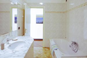 ein weißes Badezimmer mit Badewanne und Waschbecken in der Unterkunft Fernanda Apartment - Levanto in Levanto + 18 Fotos