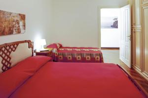 1 Schlafzimmer mit 2 Betten und einer roten Decke in der Unterkunft Fernanda Apartment - Levanto in Levanto