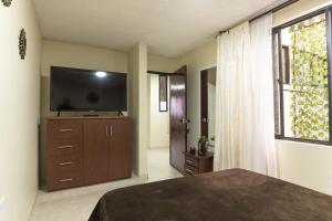 a bedroom with a flat screen tv on a dresser at Edificio Familia Gómez 2 in Popayan