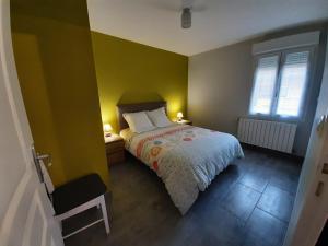 um quarto com uma cama e uma parede amarela em Gîte Les Grands Prés em Frontenard