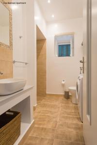 a bathroom with a sink and a toilet at Aria Apartments in Spetses