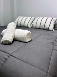 una fila de toallas blancas sentadas encima de una cama en Departamento 1A Santiago del Estero 80 en Salta