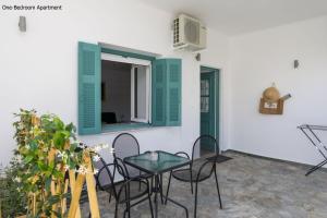 a patio with a table and chairs and a window at Aria Apartments in Spetses