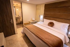 a bedroom with a large bed and a bathroom at Hotel Trugo Boutique Armenia in Armenia