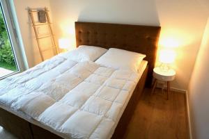 ein Schlafzimmer mit einem großen weißen Bett mit zwei Lampen in der Unterkunft Strandglück in Scharbeutz