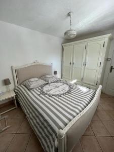una camera da letto con un letto con un piumone a righe di le lavandin a Lorgues