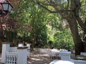 einen Park mit weißen Zäunen, Tischen und Bäumen in der Unterkunft Casa Fuente de Rechita in La Iruela