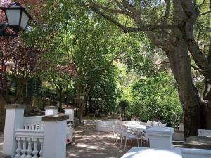 a park with white fences and tables and trees at Casa Fuente de Rechita in La Iruela