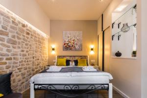 a bedroom with a bed with a stone wall at Angie Central Rooms in Zadar