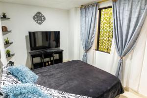 a bedroom with a bed and a tv and a window at Edificio Familia Gómez 1 in Popayan