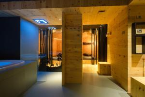 baño con paredes revestidas de madera y puerta giratoria en Residence Mille Montagne, en Andalo