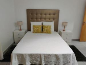 a bedroom with a large white bed with two night stands at Casa da Isabel in São Roque do Pico