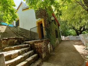 una escalera de piedra que conduce a un edificio con puerta en Casa Fuente de Rechita en La Iruela