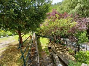 un parque con árboles y una valla con un banco en Casa Fuente de Rechita en La Iruela