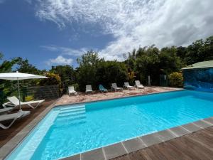 uma piscina com cadeiras e um guarda-sol em Les Gites de Bassignac em Léro