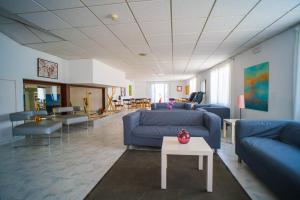 a living room with blue couches and a table at Hotel Sur in Cala Bona