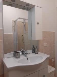 bagno con lavandino bianco e specchio di Baia Santa Reparata, grazioso bilocale con vista mare - IUN Q2157 a Santa Teresa di Gallura