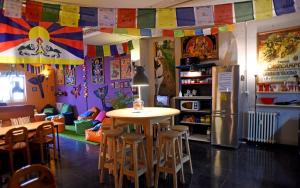 a room with a table and chairs and a refrigerator at Santander Central Hostel in Santander