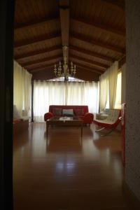 a living room with a red couch and a chandelier at Villa Marisa in Pavia