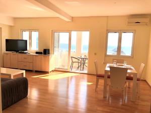a living room with a table and a dining room at Petrovac Holiday Apartments 2 in Petrovac na Moru