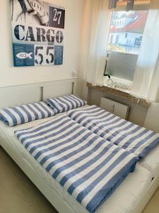 a bed with a blue and white striped mattress at Ferienwohnung "Dahme & Strandkorb" in Dahme
