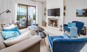 a living room with blue chairs and a fireplace at CB- Cozy refurbished apartment, perfect location in Marbella