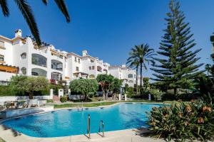 a swimming pool in front of a large building at CB- Cozy refurbished apartment, perfect location in Marbella