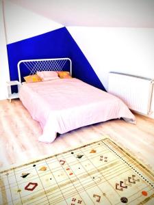 a bedroom with a bed with a blue wall at Une maison design dans le centre ville in Foix +4 photos