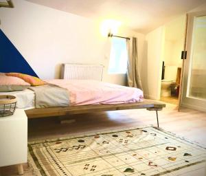a bedroom with a bed and a rug on the floor at Une maison design dans le centre ville in Foix