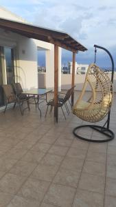 un patio con sillas y una mesa en el techo en ILIANA.APARTMENTS en Kardámaina