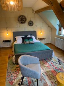 een slaapkamer met een groot bed en een stoel bij malitourne in Brissac-Quincé