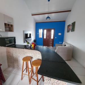 a kitchen with a counter and two stools at Casas Bela da Chapada in Lençóis