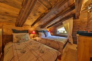 Dormitorio en cabaña de madera con 2 camas en Chalet Hohneck 4 étoiles, vieux bois et pierre, SPA, sauna, borne de recharge, en Stosswihr