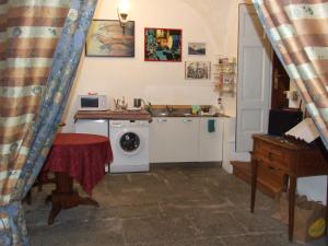 a kitchen with a washing machine and a table at La stufa rossa in Sondrio