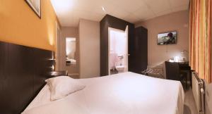 a bedroom with a white bed and a bathroom at Alpha Hotel in Ostend