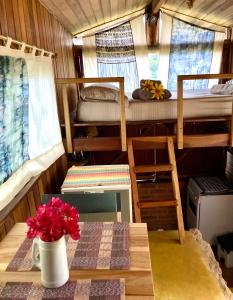 een kamer met een tafel met een vaas met bloemen bij Abrigo de montanha - Berghütte in São Bento do Sapucaí