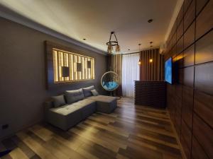 een woonkamer met een bank en een televisie bij Apartment Vokzal 2 in Samarkand