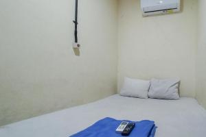 ジャカルタにあるSwahouse Tanjung Priok Syariah Mitra RedDoorzのベッド1台(リモコン付)が備わる客室です。