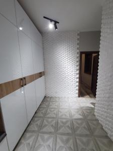 een lege kamer met witte kasten en een tegelvloer bij Apartment Vokzal 2 in Samarkand