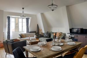 een woonkamer met een houten tafel en stoelen bij Résidence L'Aristide Appartement Gustave in Auray