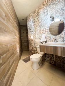 a bathroom with a toilet and a sink and a mirror at Hotel Hai Do in Bernal +32 photos
