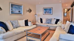 a living room with two couches and a coffee table at Harbourside Apartment in Mevagissey