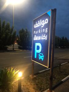 un panneau de stationnement en face d'un parking dans l'établissement ركن مدهال للوحدات السكنية المفروشة, à Jazan