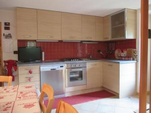 a kitchen with wooden cabinets and a stove top oven at Chalet Borney in Fontainamore