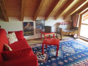 a living room with a red couch and a table at Chalet Borney in Fontainamore