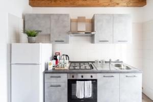 una cucina bianca con lavandino e frigorifero di Historic Center Apartment - Catania Stays a Catania