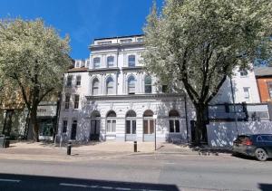 a white building with trees in front of it at City Centre Duplex Sleeps 4 #H9 in Hull