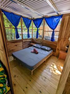 ウビタにあるArboura Eco Cabinsの青いカーテンが備わるベッドルーム1室です。 +37枚の写真