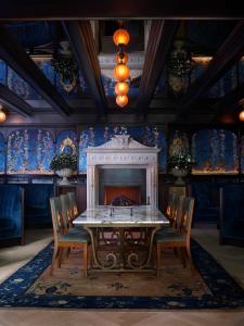 a dining room with a table and chairs and a fireplace at NoMad London in London