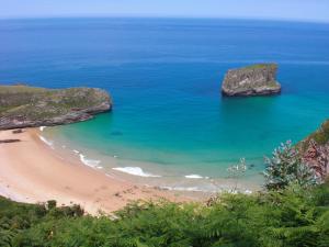 eine Luftansicht auf einen Strand mit Felsen im Ozean in der Unterkunft Acogedor apartamento en Llanes in Parres de Llanes